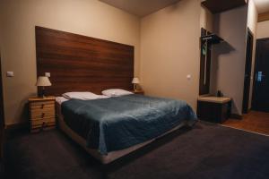 um quarto com uma cama grande e uma cabeceira em madeira em Crystal Hotel em Estosadok