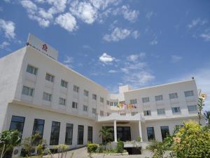 a white building with a blue sky in the background at SRM Hotel in Tuticorin