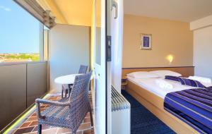 a hotel room with a bed and a table and chairs at Hotel Dražica - Hotel Resort Dražica in Krk