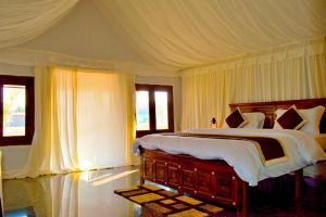 a bedroom with a large bed with a canopy at Thour Nature Resort - Jawai Leopard Safari Camp in Bera