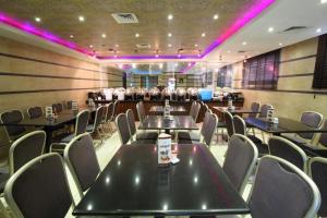 a conference room with tables and chairs and purple lights at Oasis Deira Hotel in Dubai