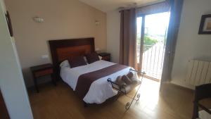 a bedroom with a bed and a large window at Hotel Rural Puerto Mágina in Torres