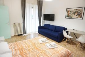 a living room with a blue couch and a desk at Bed a Cavour in Gaeta