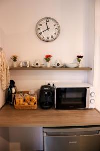 a microwave on a counter with a clock on the wall at Urban House Siurot 33 in Seville