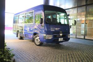 福岡市にあるホテルトラッド博多の建物前に停車する青いバス
