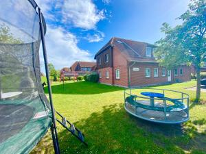 a tent in a yard with a trampoline at Ferienwohnungen Matschak OG rechts in Fehmarn