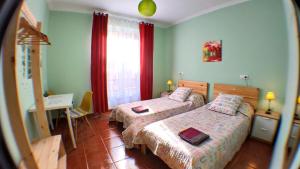 a bedroom with two beds and a desk and a window at GoodHouse in Gijón