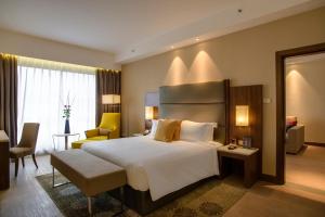 a hotel room with a bed and a chair at Crowne Plaza Nairobi Airport by IHG in Nairobi