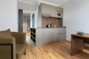 una cucina e un soggiorno con divano e tavolo di Brera Serviced Apartments Ulm a Ulma