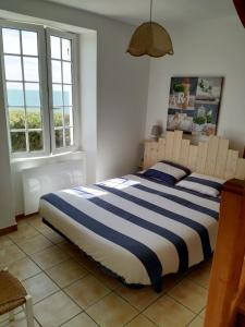 a bedroom with a bed with blue and white stripes at Vue imprenable sur la mer à Batz sur Mer in Batz-sur-Mer