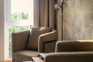 a living room with a chair and a window at Brera Serviced Apartments Ulm in Ulm