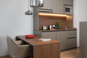 a small kitchen with a wooden table and a chair at Brera Serviced Apartments Ulm in Ulm +27 photos