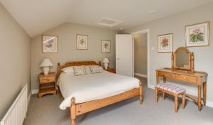 ein Schlafzimmer mit einem Bett, einem Tisch und einem Spiegel in der Unterkunft Belle Isle Castle and Cottages in Enniskillen
