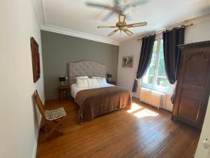 a bedroom with a bed and a ceiling fan at Manoir de la Marjolaine in Cabourg