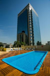 uma piscina em frente a um edifício alto em Novotel Porto Alegre Tres Figueiras em Porto Alegre