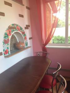 jadalnia ze stołem i krzesłami oraz oknem w obiekcie The Garden w mieście Myrhorod