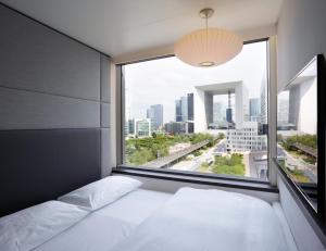 Een bed of bedden in een kamer bij citizenM Paris La Défense