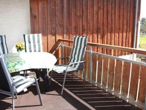 2 Stühle und ein Tisch auf einer Veranda in der Unterkunft Ferien- und Obsthof Dillmann in Langenargen