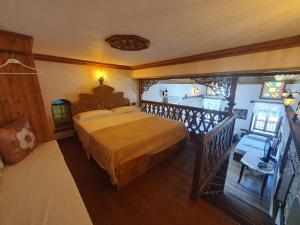 a bedroom with a large bed and a balcony at RIVA Guest House in Gjirokastër