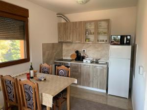 a kitchen with a table and a white refrigerator at Apartment Gaj in Zlatibor