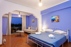 Un dormitorio azul con una cama con toallas. en CHAMBRE BLEUE en Ialyssos