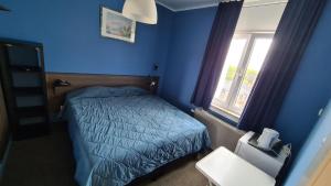 a blue bedroom with a bed and a window at hotel Melissa in Péruwelz