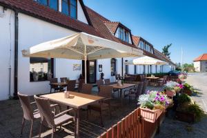 un patio al aire libre con mesas, sillas y sombrillas en Hotel Floret en Pruhonice