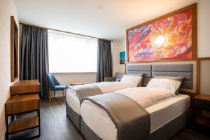 2 Betten in einem Hotelzimmer mit Wandgemälde in der Unterkunft SWAS by Livingdowntown in Zürich
