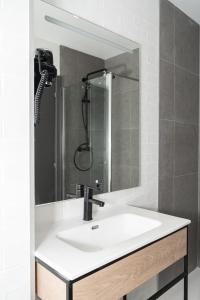 a bathroom sink with a shower and a mirror at Pension H30 SALCES Licencia HBI01292 in Bilbao