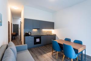eine Küche und ein Esszimmer mit einem Tisch und blauen Stühlen in der Unterkunft SWAS by Livingdowntown in Zürich + 11 Fotos