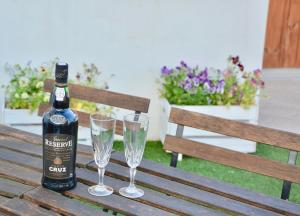 - une bouteille de vin et deux verres sur un banc en bois dans l'établissement Porto Garden Villas | Downtown, à Vila Nova de Gaia