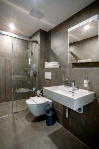 ein Badezimmer mit Waschbecken, Toilette und Dusche in der Unterkunft SWAS by Livingdowntown in Zürich