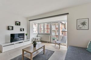 ein Wohnzimmer mit Sofa und Fernseher in der Unterkunft Flat Antoine in De Panne
