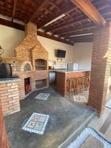 uma cozinha com um forno de tijolos num quarto em Pousada Vale do Café em Bueno Brandão