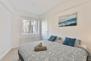 ein Schlafzimmer mit einem Bett, auf dem ein Stofftier liegt in der Unterkunft Flat Antoine in De Panne