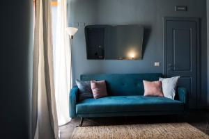 a blue couch in a living room with a mirror at Le Stanze del Cioccolato in Modica