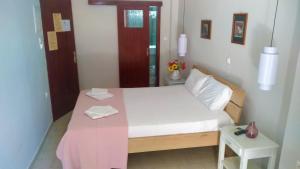 Dormitorio pequeño con cama con manta rosa en Posidonio Hotel en La Canea