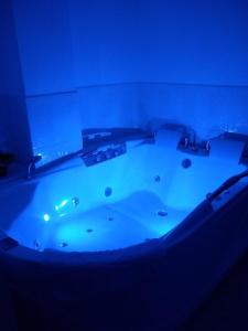 a bathtub with a blue light in a room at Hotel Anzea in Anserma