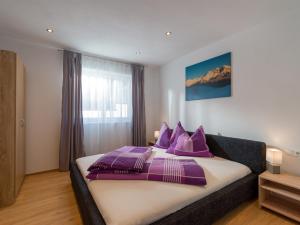 a bedroom with a large bed with purple pillows at Ferienwohnung Treichl in Itter