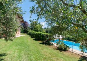 a garden with a swimming pool and trees at Agriturismo Il Poggio, Casa Pietra in Umbertide