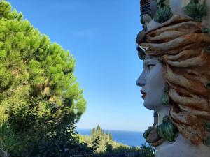 uma estátua de uma mulher olhando para o oceano em Casal Trinacria em Santa Teresa di Riva