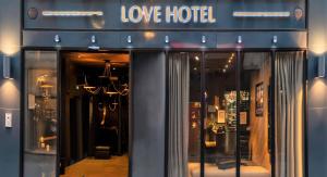 a store front with a love hotel sign on it at Love Hôtel avec nuit insolite au Dandy et Jacuzzi privatisé in Paris