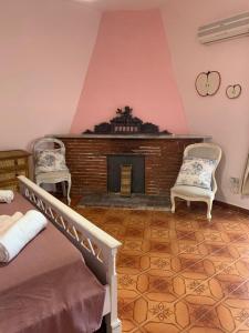 ein Wohnzimmer mit 2 Stühlen und einem Kamin in der Unterkunft B&B Casa Franca in Postiglione