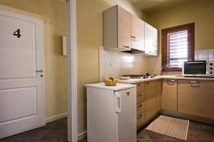 a kitchen with a white refrigerator and a microwave at Le Stanze del Cioccolato in Modica