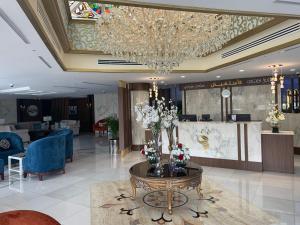 فندق جولدن بوجاري الخميس في خميس مشيط: لوبي فيه ثريا وطاولة فيها ورد