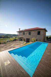 a large blue swimming pool in front of a house at Quinta da Casa Nova in Santo Tirso