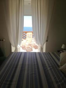 a bedroom with a bed and a view of the ocean at On the sea in Santa Marinella