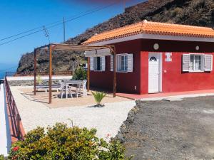 a red house with a table in front of it at Casita los vergas in Las Indias
