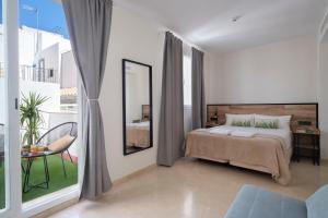 a bedroom with a bed and a mirror at Sweet Sevilla Suites in Seville