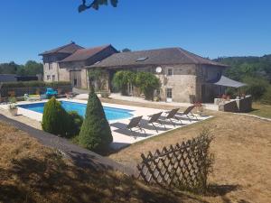 une maison avec une piscine en face d'une maison dans l'établissement Les hauts Brianço, à Solignac